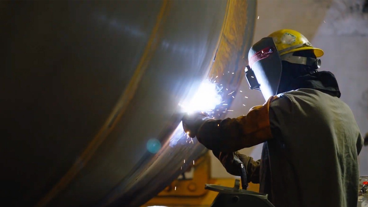 Welder working on a railcar with sparks flying.