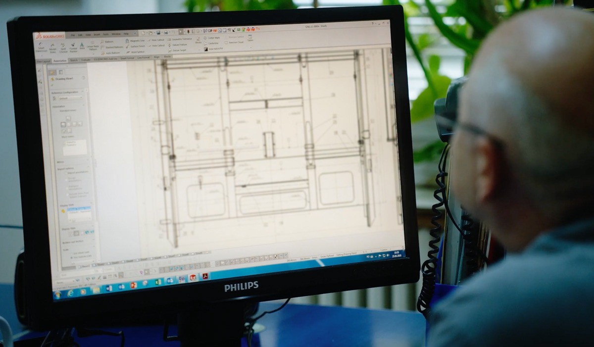 Engineer at computer drawing on desktop.