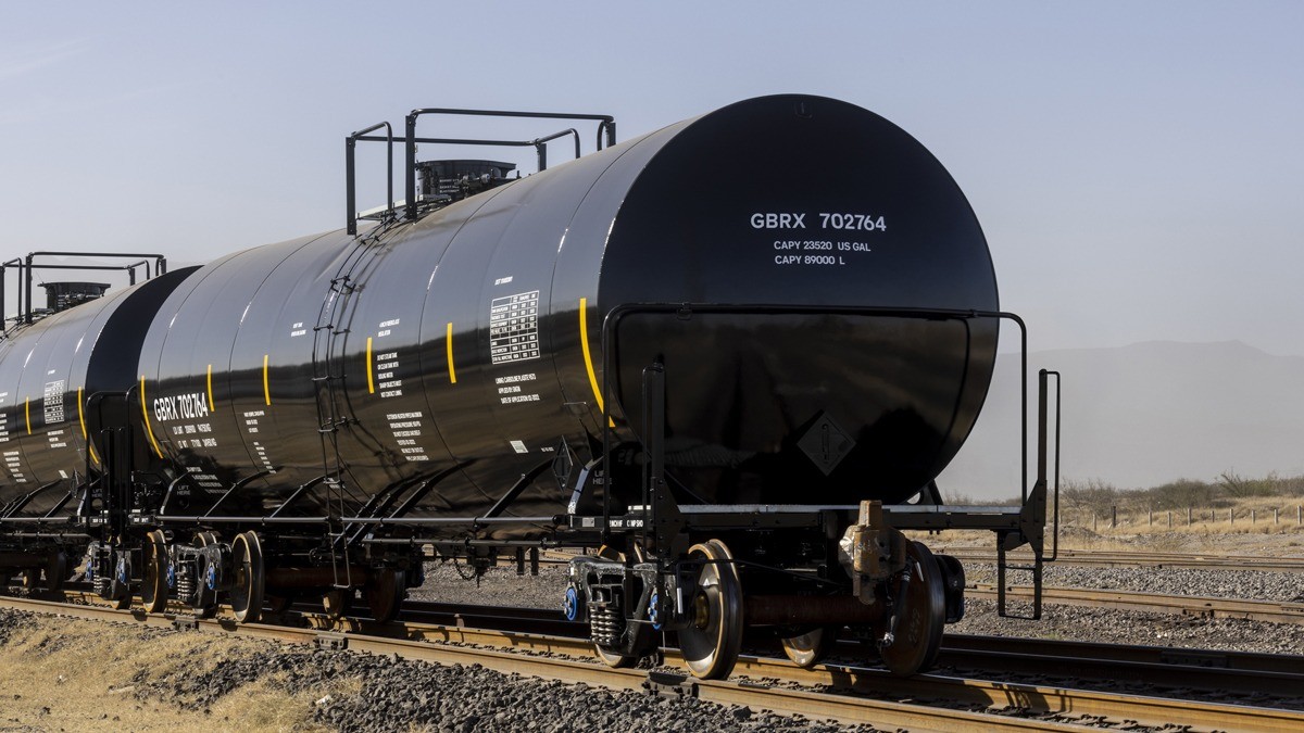 Black tankcars riding across the track.
