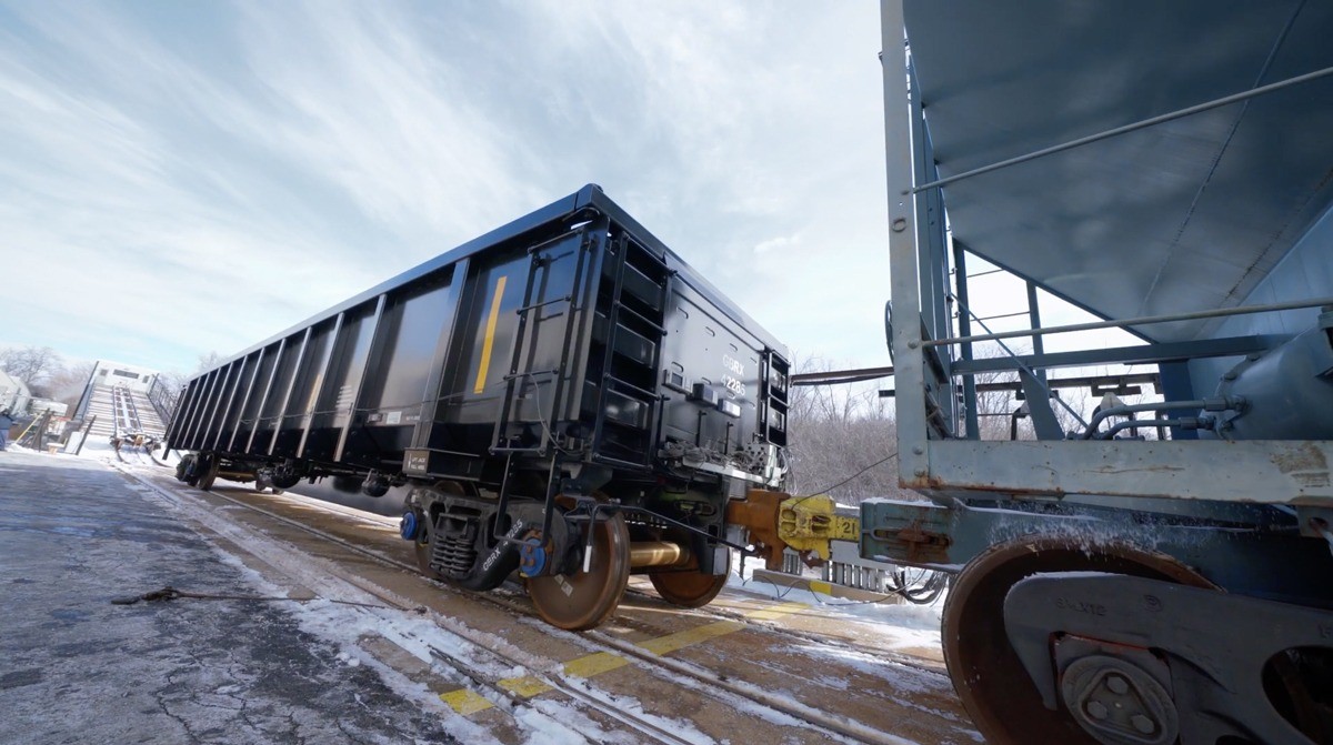 Black gondola being connected to another railcar